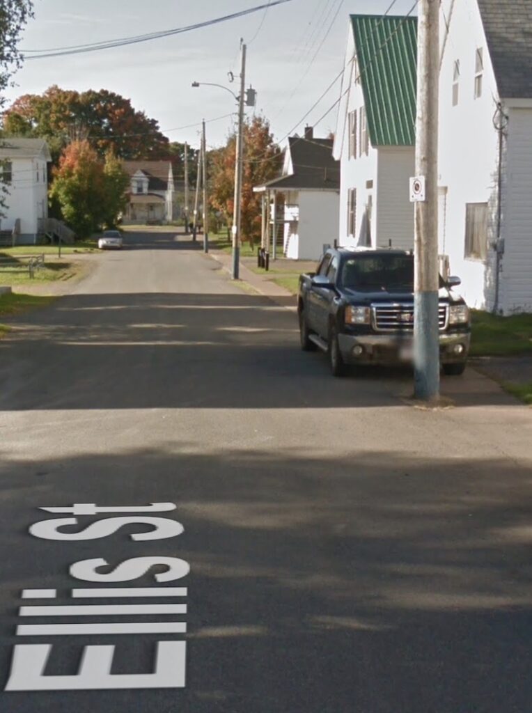 A vehicle parked on the sidewalk, Ellis Street, Oxford, NS.