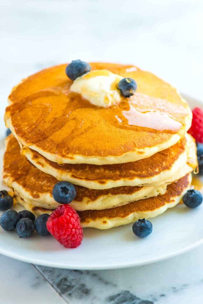 Pancakes on a plate with blueberries and strawberries