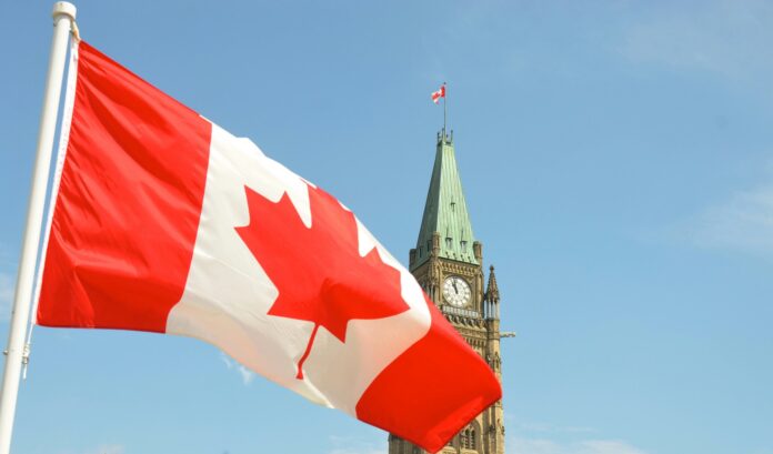 The Canadian Flag waving in front of the Parliament building